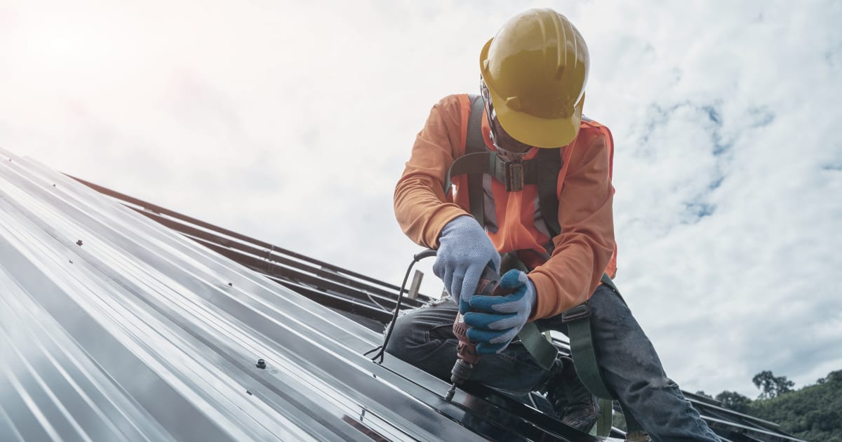 Un esperto effettua migliorie nella coibentazione del tetto di una casa unifamiliare 