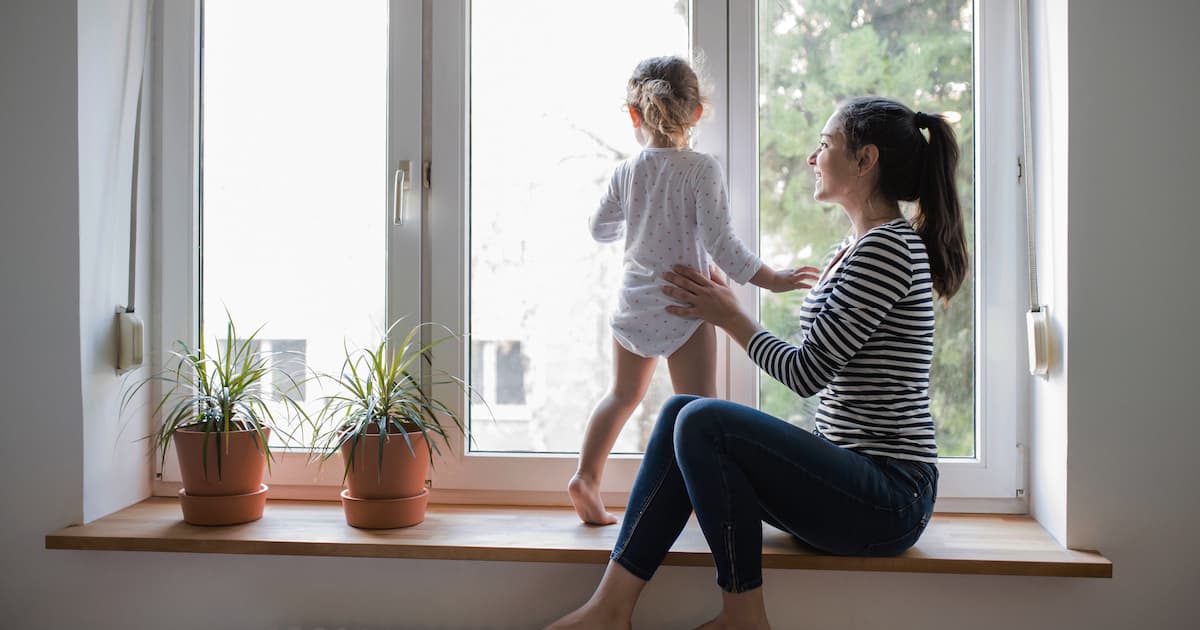 A life insurance policy protects families in the event of a loss. A mother and daughter look out of the window.