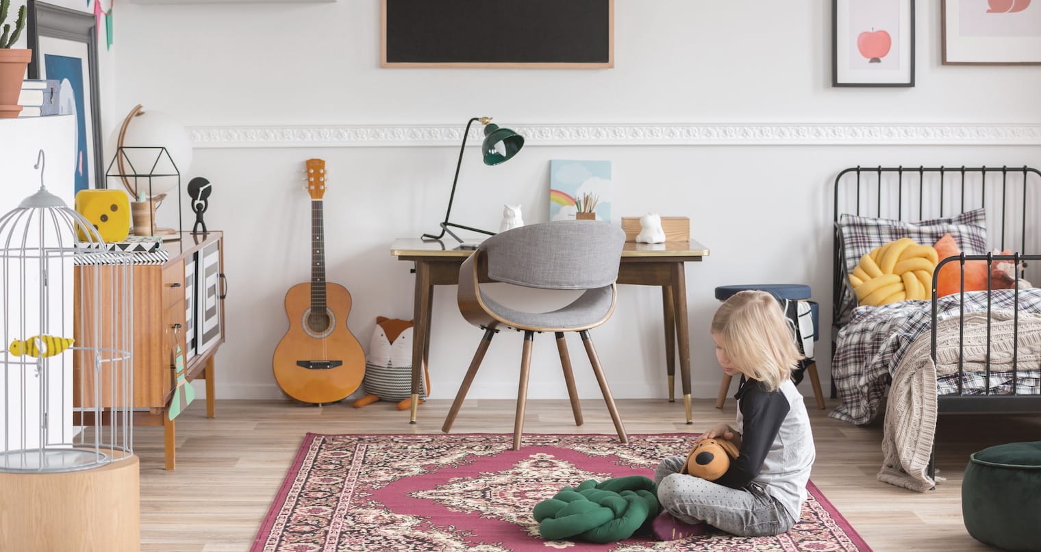 Ein Kind spielt mit einem Plüschtier in seinem Kinderzimmer