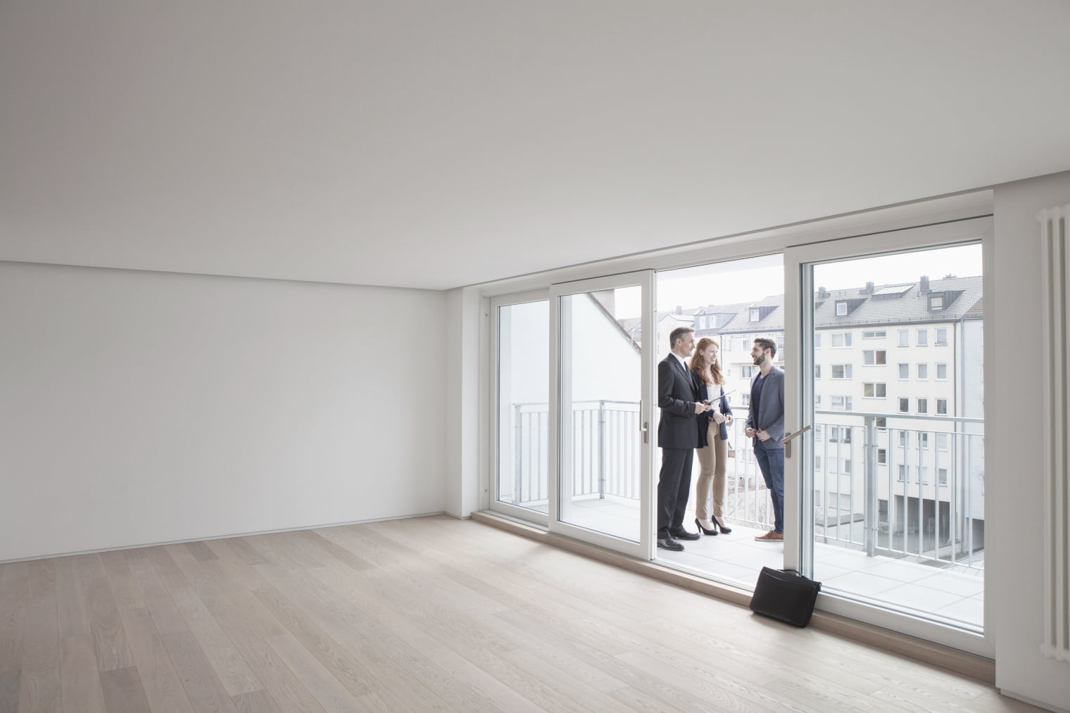 Three people on the balcony of a new apartment